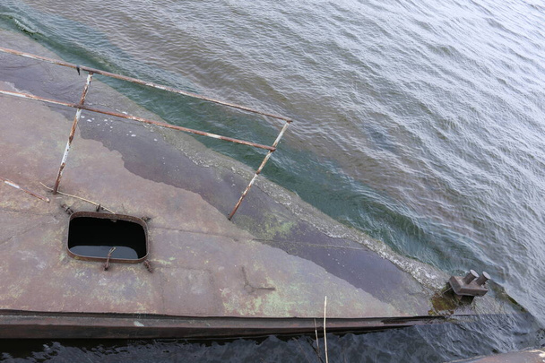 Vecchio molo arrugginito affondato nell'acqua sul territorio del porto fluviale. Vecchia struttura arrugginita affondata sul fiume. - Foto, immagini