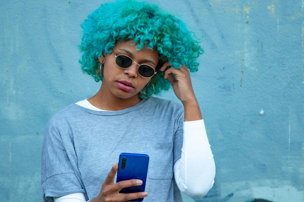 negro afro americana mujer mirando el teléfono móvil en la calle - Foto, Imagen
