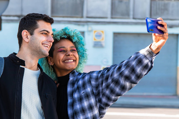 feliz casal multiétnico tirar uma foto com telefone celular na rua - Foto, Imagem