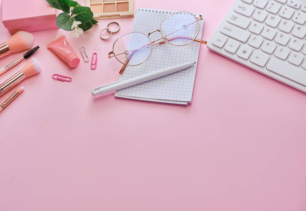 Banner Flat lay, bovenaanzicht roze modern bureau. Werkruimte met toetsenbord, notitieblok, bril, pennen, beauty accessoires op roze achtergrond. Online werken, winkelen, cursussen en trainingsconcept - Foto, afbeelding