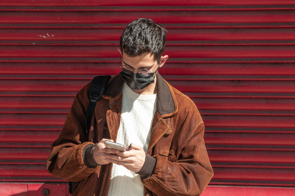 man with mask and mobile phone on the street - Foto, Imagen
