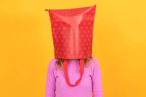 mujer aislada con bolsa de compras en la cabeza estresada - Foto, imagen