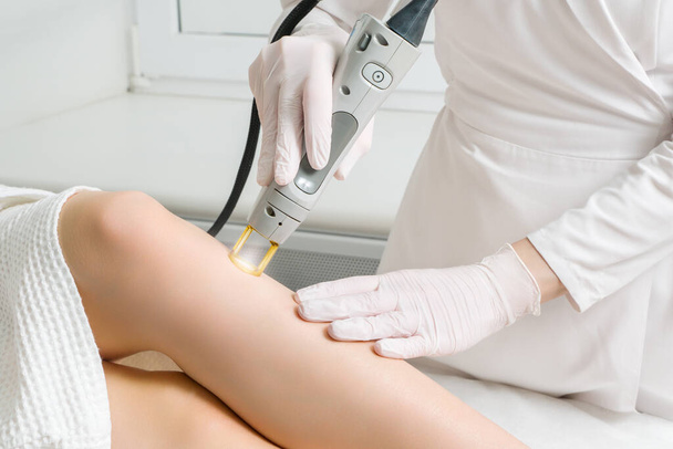 The procedure for removing hair on the body of a woman in a cosmetology clinic. Laser hair removal. - Photo, Image