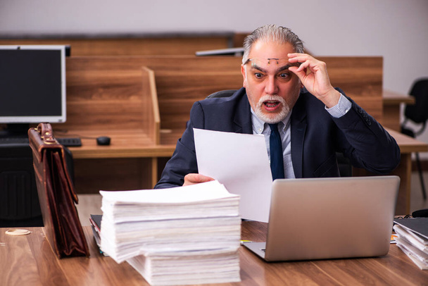 Old male employee and too much work in the office - 写真・画像