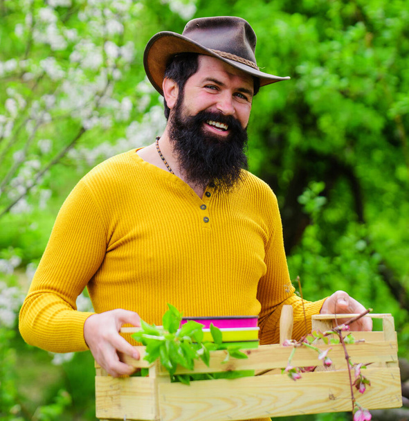 Happy farmer in spring garden. Bearded man with box. Eco farm. Gardener work. - Photo, Image