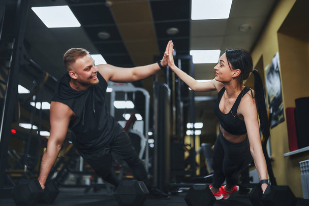 Strong and Beautiful Athletic Fitness Couple in Workout Clothes Doing Push Up Exercises and Giving Each Other a High Five - Fotoğraf, Görsel