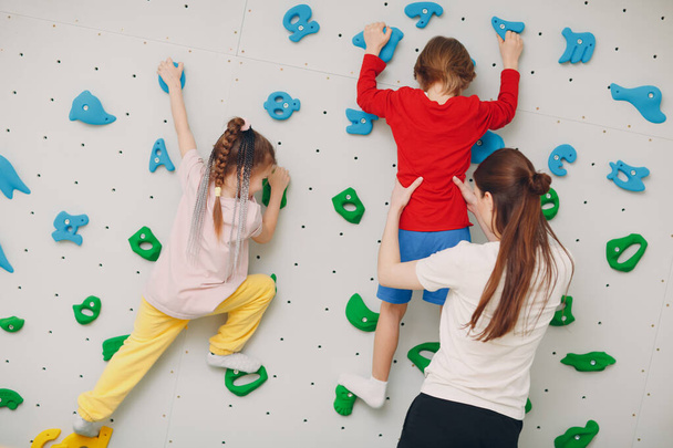 Kid child at climbing wall. Children sport, healthy lifestyle in kindergarten or sport center in school - Photo, image