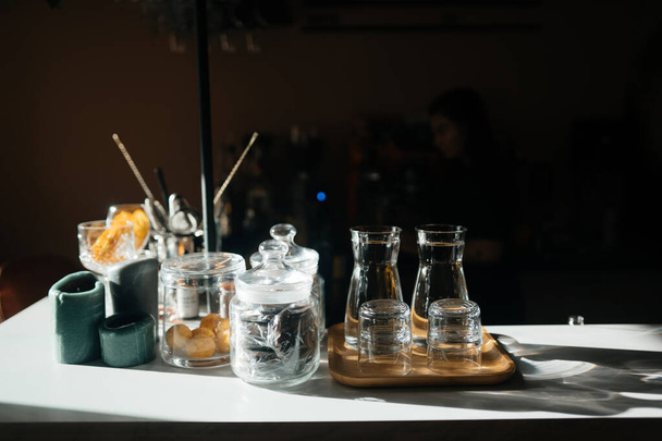 Quatre tasses en verre sur le comptoir du bar avec accessoires de service. - Photo, image