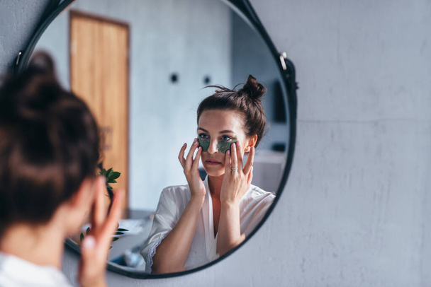 Young woman takes care of her facial skin at home - Foto, Imagem