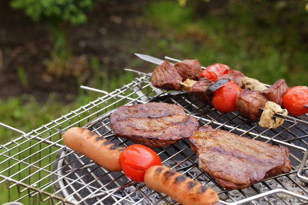 Cooking on the barbecue grill assortment sausages steak and skewers - Photo, Image
