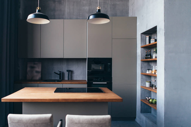 Modern kitchen with table and built-in hob. - Fotó, kép