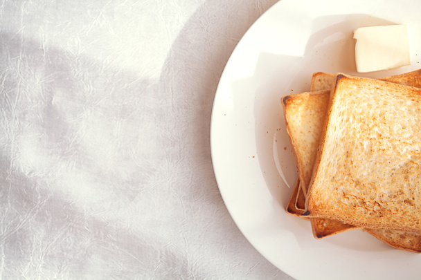 Fette di pane tostato con tappetino al burro per colazione
 - Foto, immagini