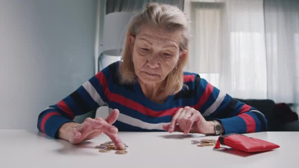 Бедная старуха считает монеты на столе. Низкая пенсия и недостаток средств - Кадры, видео