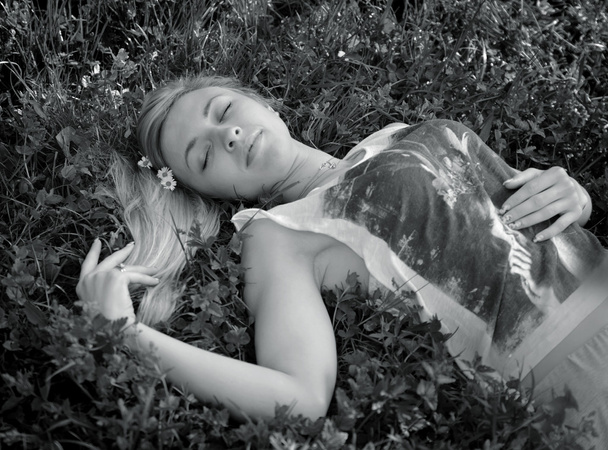 Young beautiful woman  lying on the grass - Foto, afbeelding