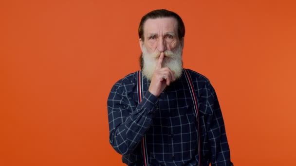 Oudere man met baard duwt wijsvinger op lippen maakt stiltegebaar vertelt geen geheim - Video