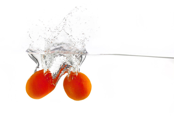 two tangerines falls into the water on a white background, isolate, place under the text - Foto, Imagem