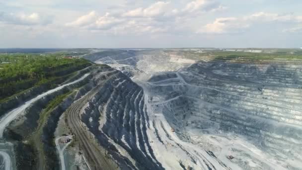 Aerial view panorama of Huge asbestos quarry with and railway. Inside the quarry there is a excavators and serpentine road for trucks. Summer sunny day. At the top of the quarry there is a forest - Footage, Video
