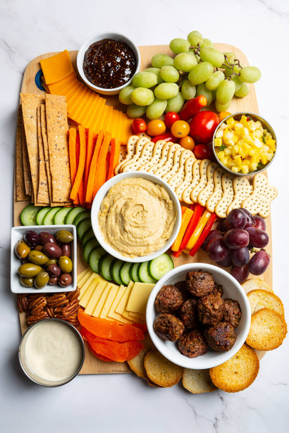 Vegan and vegetarian Charcuterie boards of assorted cheeses, meats and appetizers. Above view table scene on a marble background. - Photo, Image
