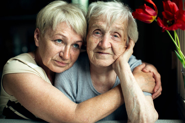 Portrait d'une vieille femme avec sa fille à la maison. - Photo, image