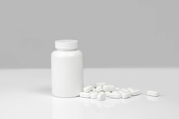 Medical background of many white capsule tablets or pills on the table. Mock up container. Healthcare pharmacy and medicine concept with copy space Painkillers or prescription drugs consumption - Φωτογραφία, εικόνα
