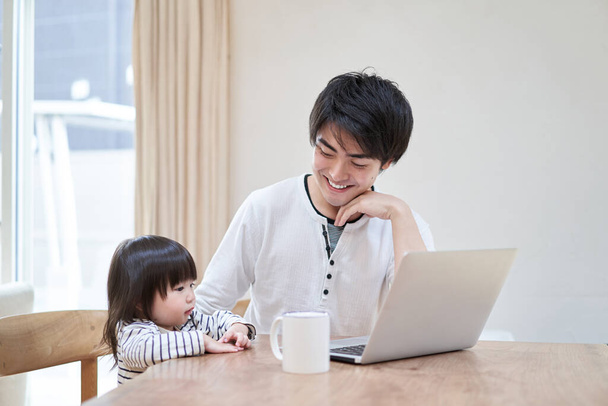 aziatische vader babysitters terwijl telewerken - Foto, afbeelding
