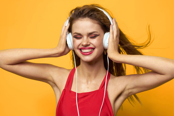 woman in headphones listening to music red t shirt emotions fashion yellow background lifestyle - Fotografie, Obrázek