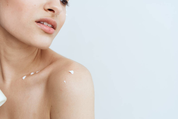 Jolie brunette épaules nues lotion soin de la peau - Photo, image