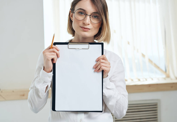  белый лист бумаги Женщина в комнате рядом с окном интерьера папки с документами - Фото, изображение
