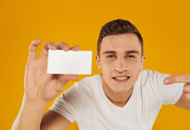 Man with white card on yellow background Copy Space mockup - Photo, Image
