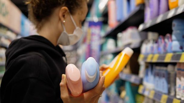 Hoarding during covid 19 outbreak. Caucasian woman in face mask shopping for products in store to stock up - Zdjęcie, obraz