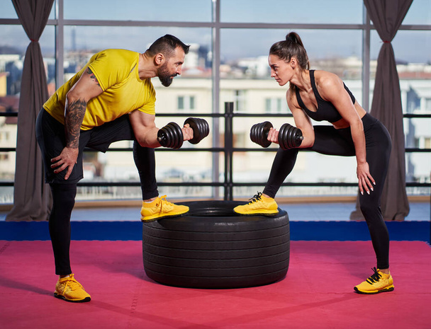 Young fitness couple doing workout in the gym by the window - Fotoğraf, Görsel