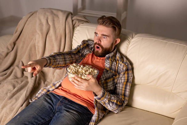 Uomo single sul divano a guardare la TV - Foto, immagini