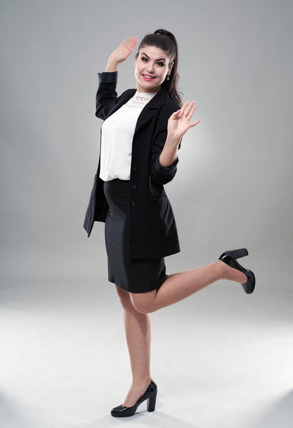 Cheerful successful young hispanic businesswoman on gray background - 写真・画像