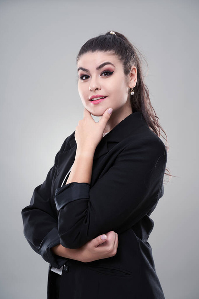 Doubtful young hispanic businesswoman with hand on chin - Foto, imagen