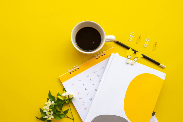 Планувальник календаря ноутбуків для бізнесу робота з гарячою кавою еспресо-аранжування плоский стиль на фоні жовтого
 - Фото, зображення