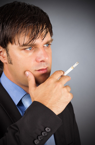 Closeup portrait of young businessman during a break smoking cig - Photo, Image