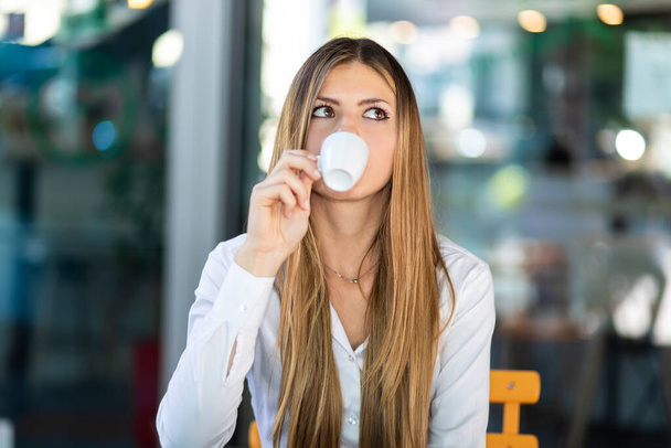 Beautiful woman having a coffee in a cafe - Фото, изображение