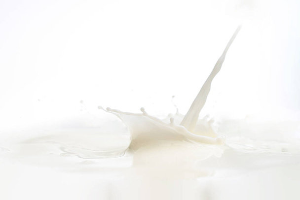 splash on the surface of milk and splashes on a blue background - Photo, image
