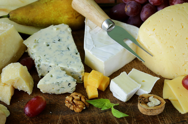 Cheeseboard with assorted cheeses (parmesan, brie, blue, cheddar) - Photo, Image