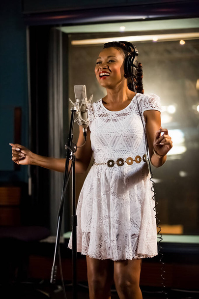 JOHANNESBURG, SOUTH AFRICA - 18 Ocak 2021: Johannesburg, Güney Afrika - 29 Nisan 2015: Arielle T, Gabon şarkıcı stüdyoda Afro-pop şarkısı üzerine vokal bölümü - Fotoğraf, Görsel