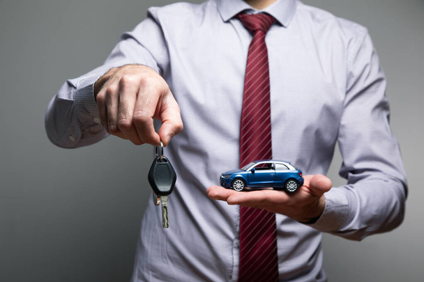 a man holding a toy car and keys in his hands . - Photo, Image