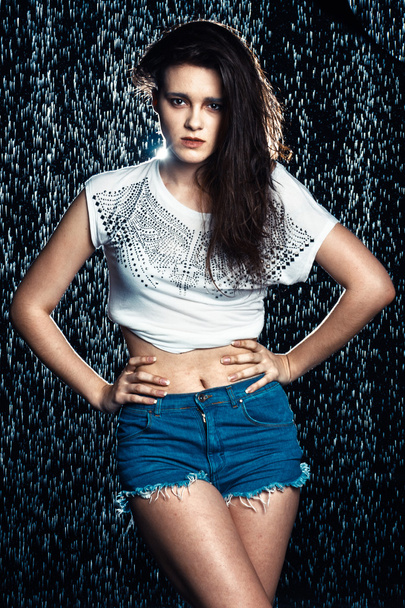 Young beautiful brunette woman posing in wet fashionable clothes - Fotó, kép