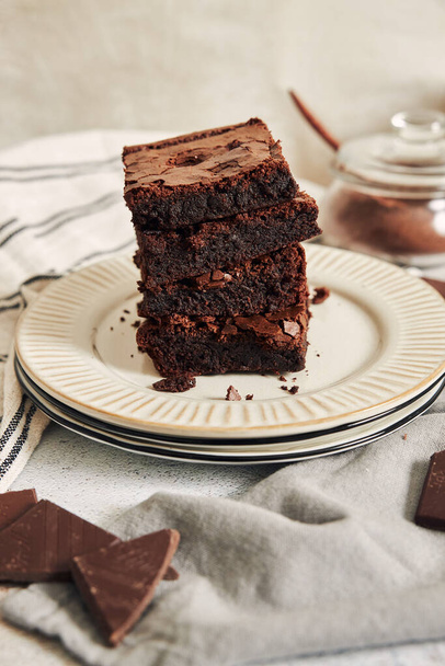 A vertical shot of delicious brownies on a white plate - Fotó, kép