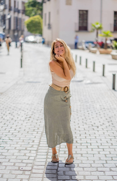 Outdoors full length portrait of young attractive woman with beautiful blonde hair and sensual smile. Female model posing with natural beauty and light. Real People, beauty care, fashion and lifestyle. - Φωτογραφία, εικόνα