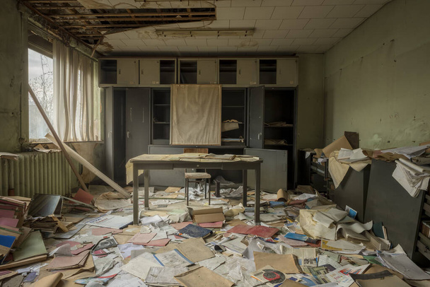 A pile of abandoned books and papers on the floor of an abandoned room - Photo, image