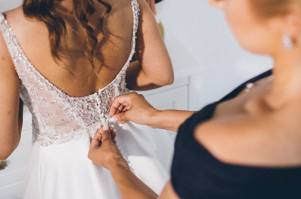 A female fixing the bride's dress - Foto, afbeelding