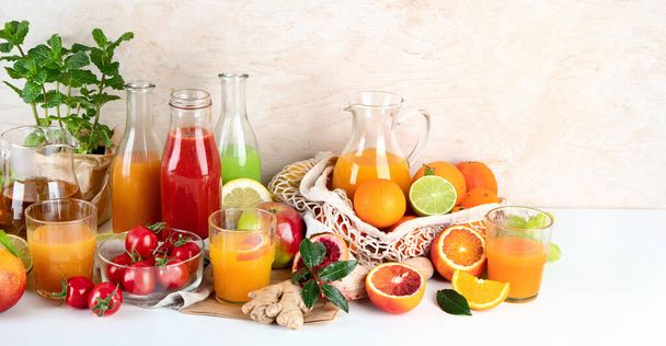 Fresh and healthy home made juices, fruits and vegetables on light wooden background. Copy space - 写真・画像