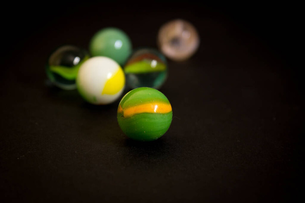 A selective focus shot of marble balls isolated on black background - Fotó, kép