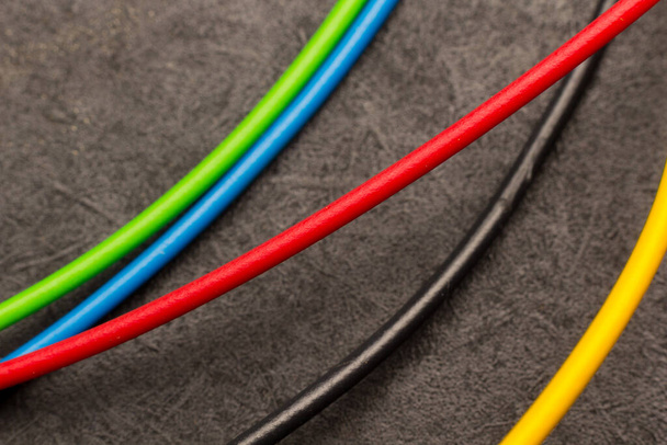 Színes elektromos kábelek; alapszínek az elektromos kábelekben. Huzalhulladék; kis darab színes huzalból; elektromos huzal. - Fotó, kép
