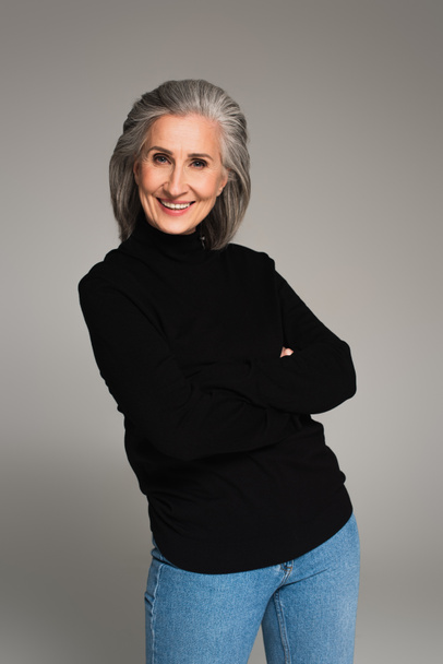 Smiling woman with crossed arms looking at camera isolated on grey  - Foto, immagini